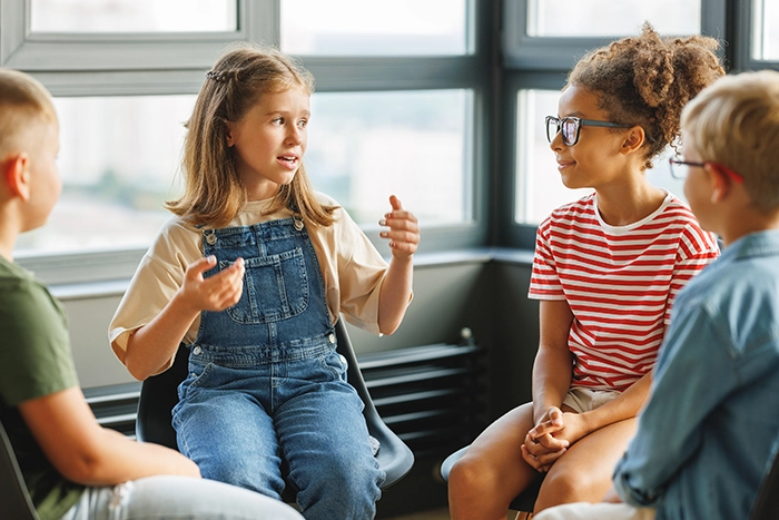 Vier Schulkinder in einer Gesprächssituation.